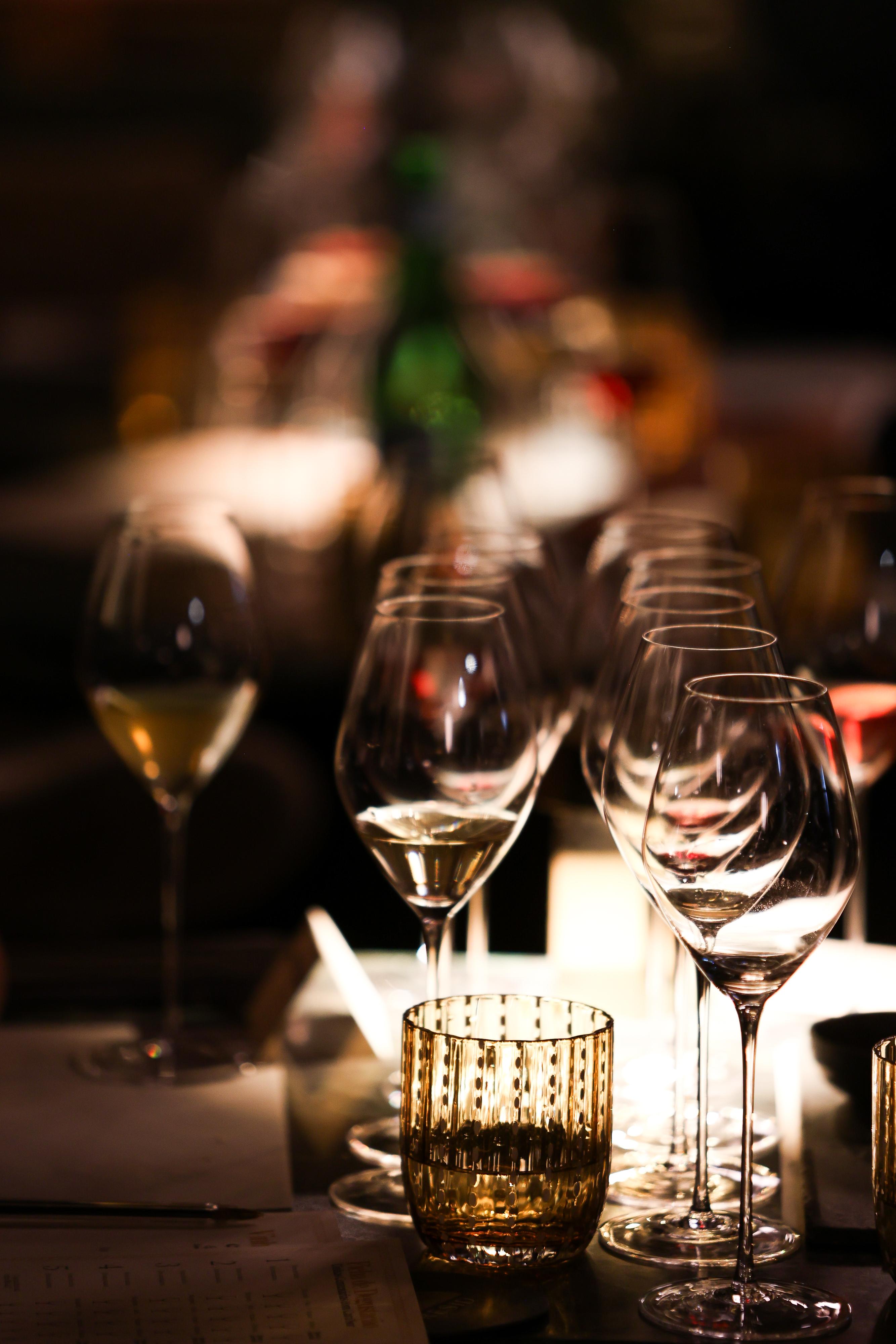 Taças de vinho iluminadas na mesa do Resid Bar